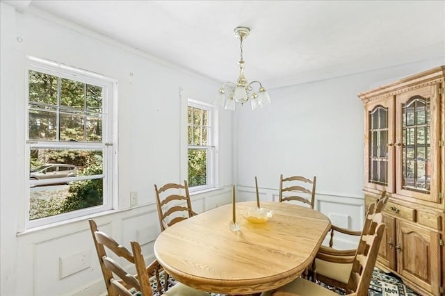 dining area with crown molding, a healthy amount of sunlight, and an inviting chandelier