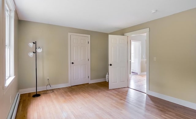 15 Reed St Unit 2, West Boylston, MA 01583 - unfurnished bedroom featuring a baseboard radiator, light wood-style flooring, and baseboards