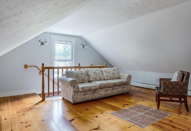 15 Reed St Unit 2, West Boylston, MA 01583 - living area with hardwood / wood-style flooring, a baseboard heating unit, vaulted ceiling, and an upstairs landing