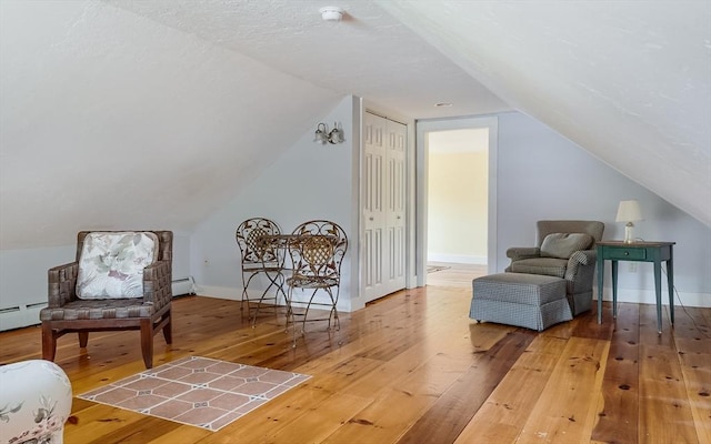 15 Reed St Unit 2, West Boylston, MA 01583 - living area with hardwood / wood-style flooring, vaulted ceiling, a baseboard radiator, and baseboards