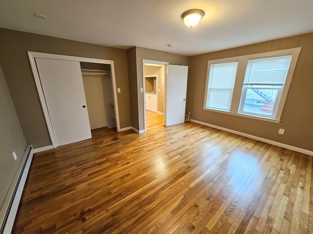 84-86R Cross St, Somerville, MA 02145 - unfurnished bedroom featuring a baseboard radiator, hardwood / wood-style floors, baseboards, and a closet