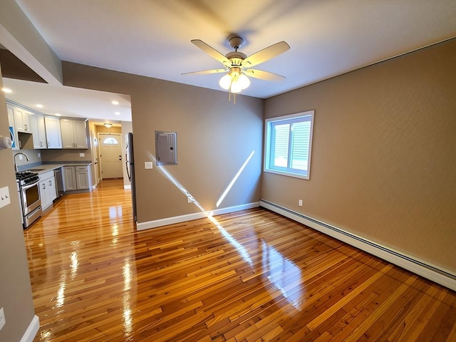 84-86R Cross St, Somerville, MA 02145 - unfurnished living room with light wood-style flooring, a baseboard heating unit, a ceiling fan, electric panel, and baseboards