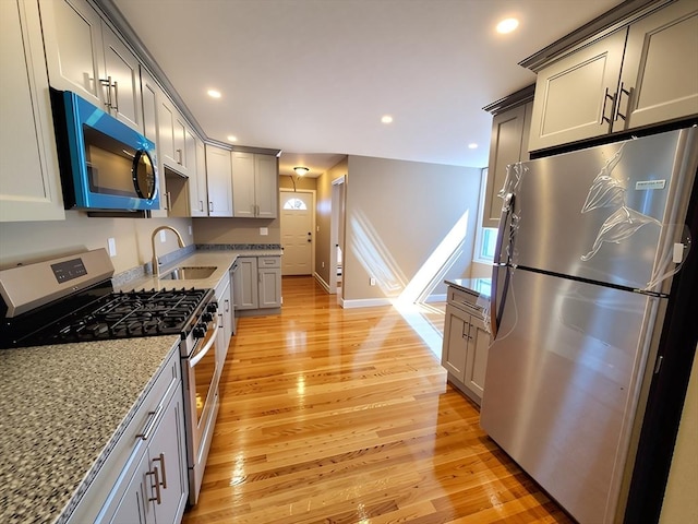 84-86R Cross St, Somerville, MA 02145 - kitchen with appliances with stainless steel finishes, a sink, light wood-type flooring, light stone counters, and recessed lighting