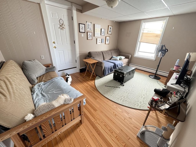 84-86R Cross St, Somerville, MA 02145 - living room with a baseboard heating unit, wood finished floors, and a paneled ceiling