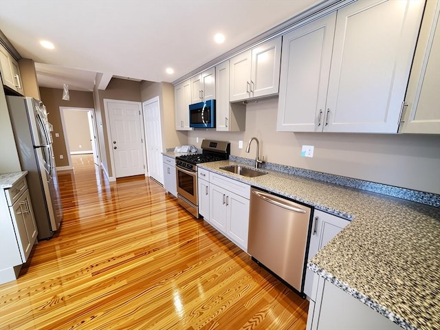 84-86R Cross St, Somerville, MA 02145 - kitchen with appliances with stainless steel finishes, a sink, light wood finished floors, recessed lighting, and light stone counters