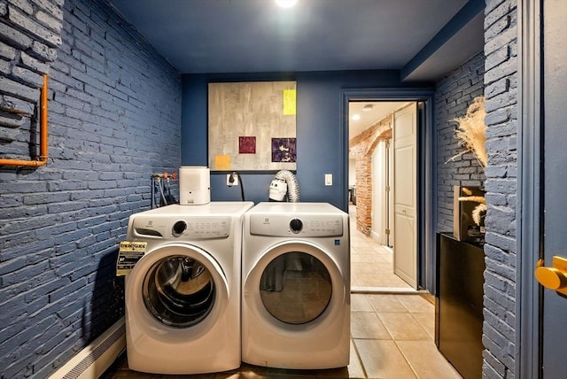 washroom featuring brick wall, light tile patterned flooring, laundry area, and washer and clothes dryer