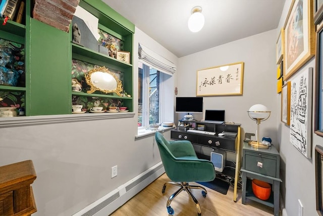 home office featuring a baseboard heating unit, wood finished floors, and baseboards