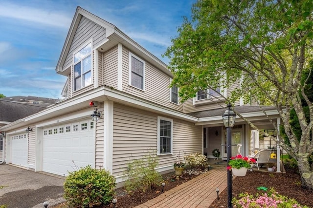 view of front of house featuring a porch, asphalt driveway, and an attached garage