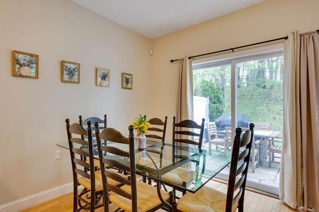 dining space with light wood-style flooring and baseboards