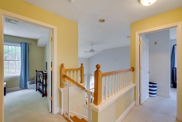 hallway featuring an upstairs landing, carpet floors, and baseboards