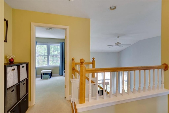 hall featuring an upstairs landing, light colored carpet, and baseboards