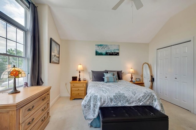 bedroom featuring lofted ceiling, light colored carpet, a closet, a ceiling fan, and baseboards