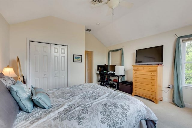bedroom featuring vaulted ceiling, light colored carpet, a closet, baseboards, and a ceiling fan