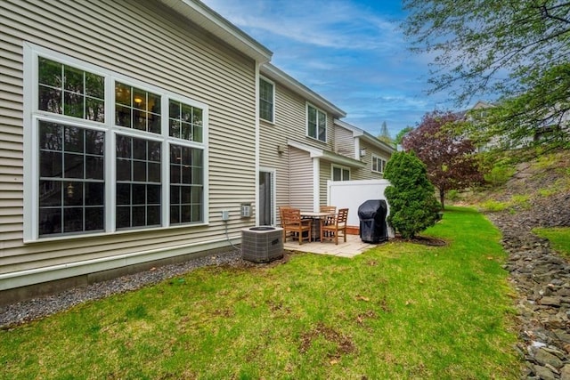 rear view of property with a patio, cooling unit, and a yard