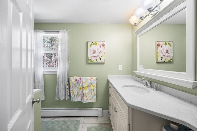 bathroom with a baseboard heating unit, baseboards, tile patterned flooring, and vanity