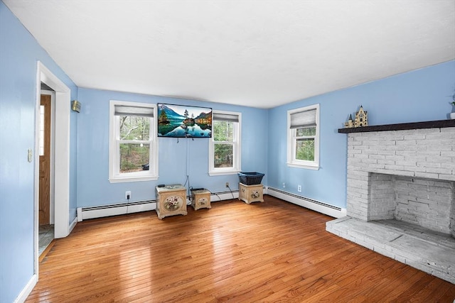 living area featuring baseboard heating, wood-type flooring, and baseboards