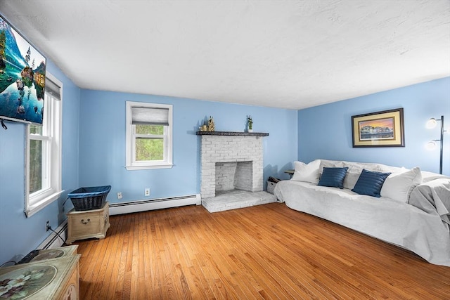 living room featuring a brick fireplace, a baseboard radiator, and wood-type flooring