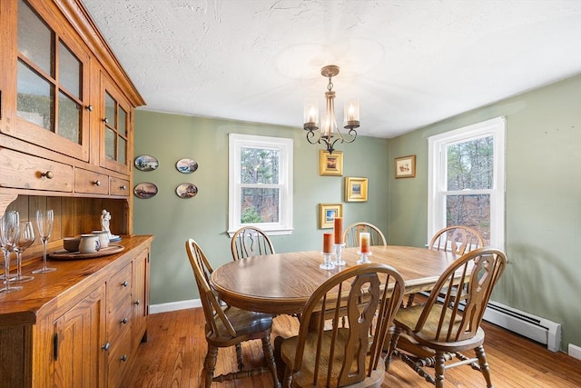 dining room with wood-type flooring, a wealth of natural light, and baseboards