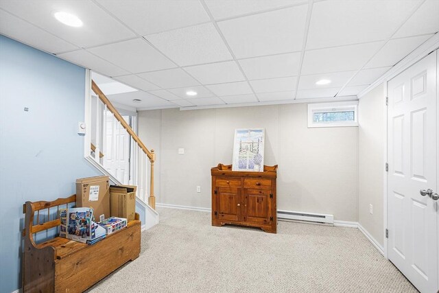 interior space featuring stairway, a baseboard radiator, carpet floors, and a drop ceiling