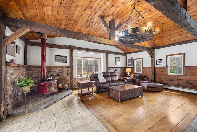 tiled living room featuring a wood stove, a wainscoted wall, wood ceiling, and lofted ceiling with beams