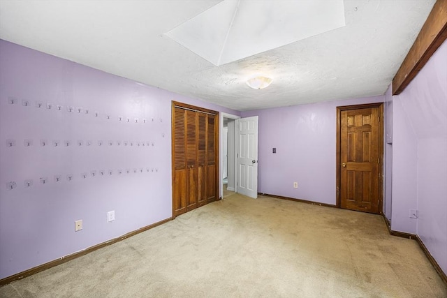 unfurnished bedroom featuring light colored carpet, baseboards, and a closet