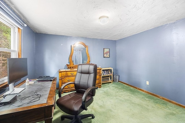 carpeted office with baseboards and a textured ceiling