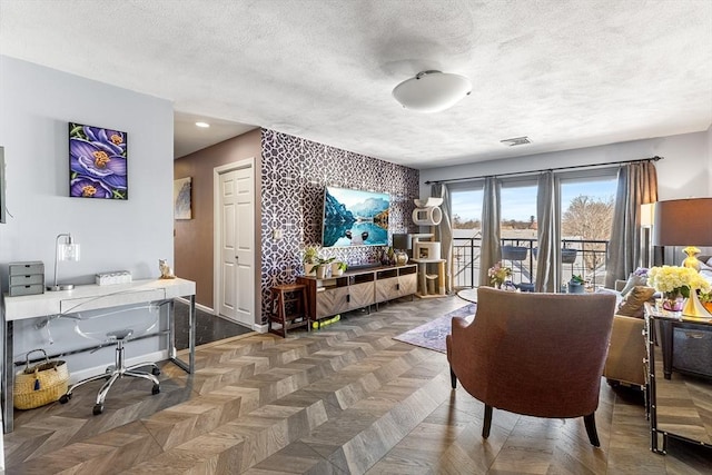 interior space with a textured ceiling, visible vents, and baseboards