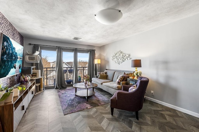 living room featuring visible vents, a textured ceiling, and baseboards