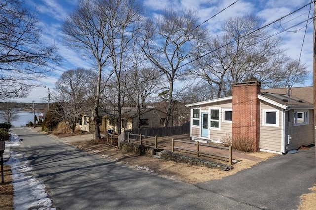 view of front of property with a chimney and fence