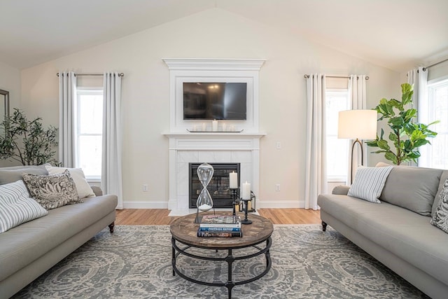 living room featuring a fireplace, lofted ceiling, and light hardwood / wood-style floors