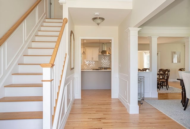 interior space with light hardwood / wood-style floors and ornate columns