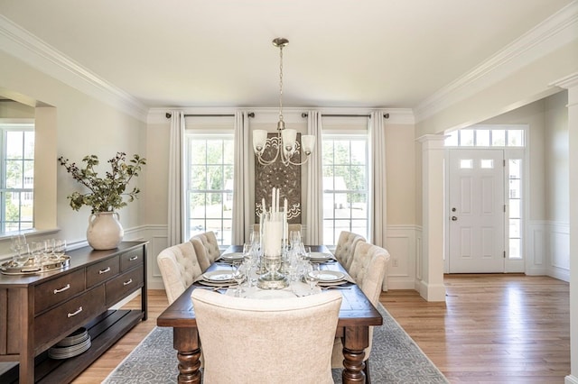 dining area featuring plenty of natural light, crown molding, and light hardwood / wood-style flooring