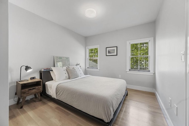bedroom featuring baseboards and light wood-style floors