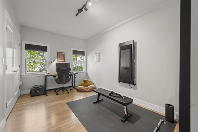 exercise area featuring baseboards and wood finished floors
