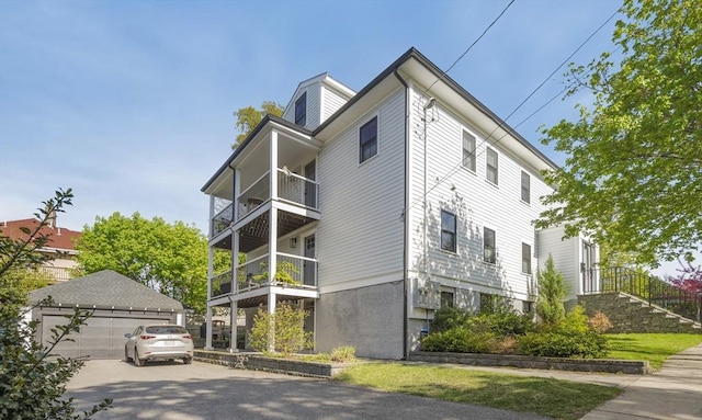 view of side of home with a balcony and a detached garage