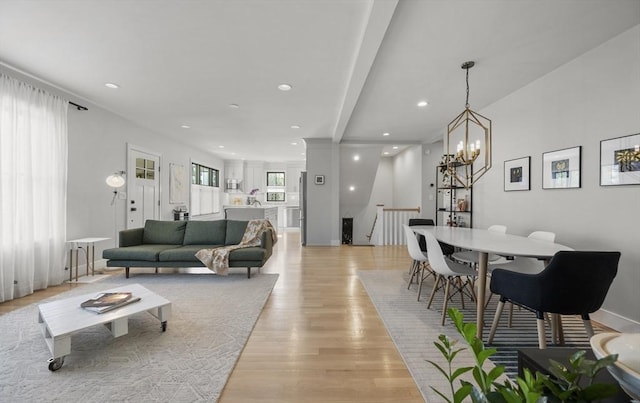 living area with baseboards, light wood-style floors, a chandelier, and recessed lighting