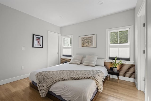 bedroom with light wood finished floors and baseboards