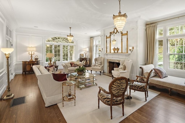 living area featuring crown molding, a fireplace, visible vents, and a decorative wall