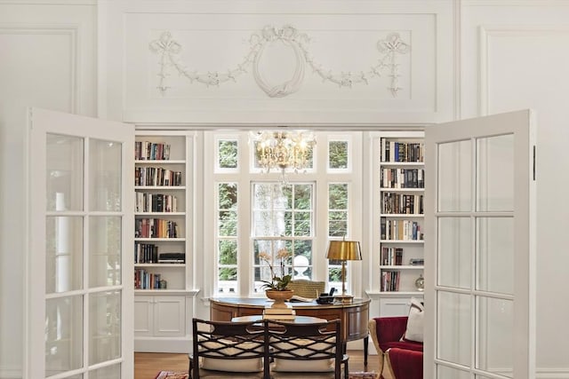 sunroom / solarium with a chandelier and french doors