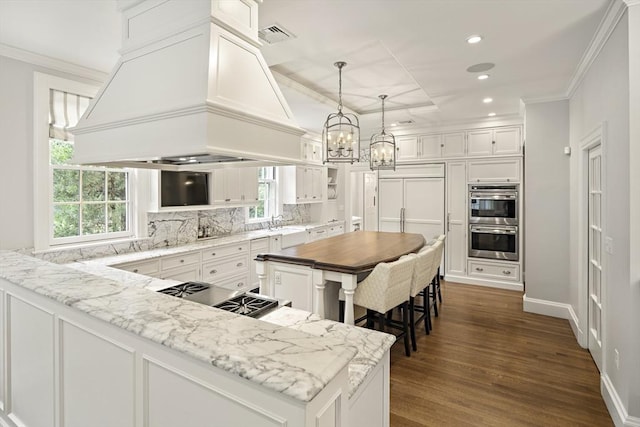 kitchen with custom exhaust hood, backsplash, ornamental molding, stainless steel double oven, and white cabinets