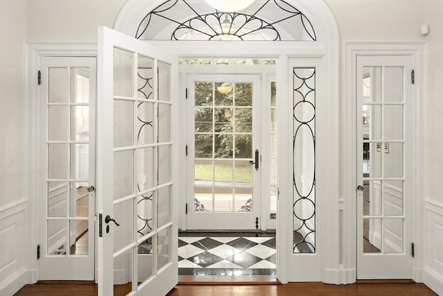 doorway to outside with a healthy amount of sunlight, wood finished floors, and french doors