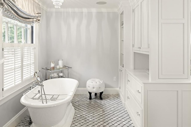 bathroom featuring a healthy amount of sunlight, a freestanding tub, ornamental molding, and a chandelier