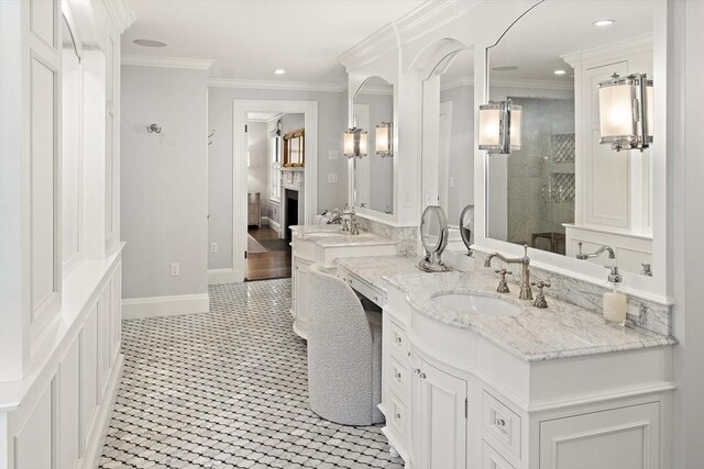 full bathroom featuring baseboards, tiled shower, crown molding, vanity, and a fireplace