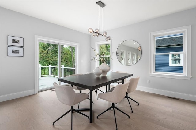67 Pine St Unit 2, Dedham, MA 02026 - dining room with baseboards, light wood-type flooring, and a chandelier