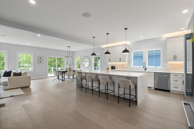 67 Pine St Unit 2, Dedham, MA 02026 - kitchen featuring stainless steel dishwasher, recessed lighting, light wood-style floors, a center island, and a breakfast bar area