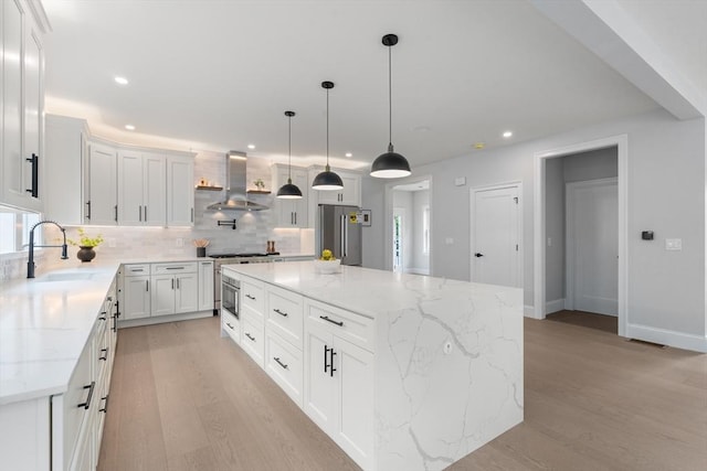 67 Pine St Unit 2, Dedham, MA 02026 - kitchen featuring wall chimney range hood, a sink, high end appliances, light wood-style flooring, and decorative backsplash