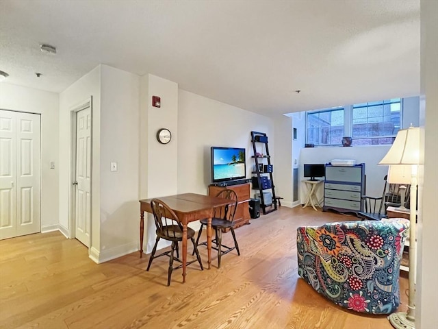 dining space featuring light wood-style flooring and baseboards