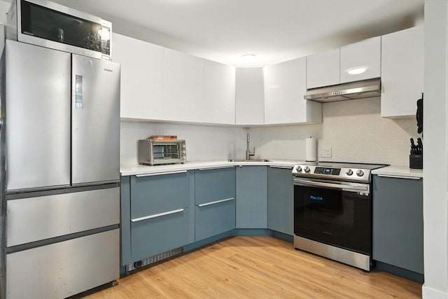 80 E Brookline St Unit 1, Boston, MA 02118 - kitchen featuring stainless steel appliances, range hood, a sink, and light countertops