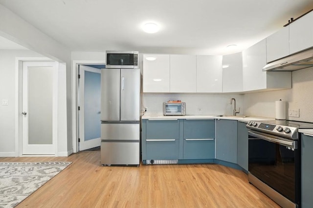80 E Brookline St Unit 1, Boston, MA 02118 - kitchen featuring appliances with stainless steel finishes, decorative backsplash, a sink, and white cabinets