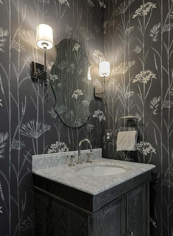 bathroom featuring vanity and wallpapered walls